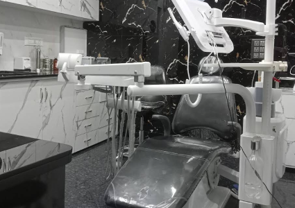  Dental chair in room with black and white marble walls.