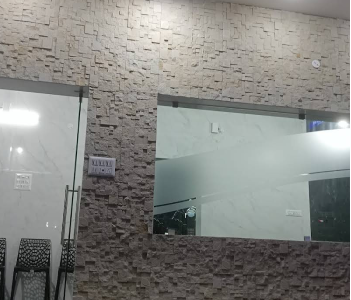 Glass wall reflecting chairs, creating illusion of more space.