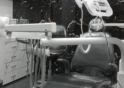 Dental chair in room with black and white marble wall.